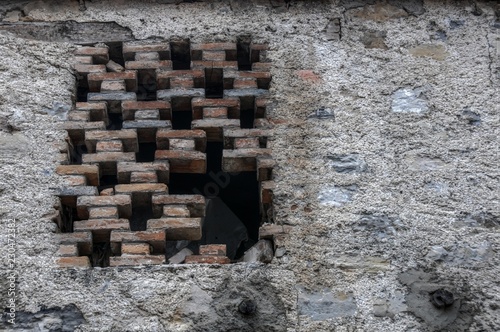 Fototapeta Naklejka Na Ścianę i Meble -  Partly-bricked window in barn wall, Cabbio in rural Ticino (Italian Switzerland)