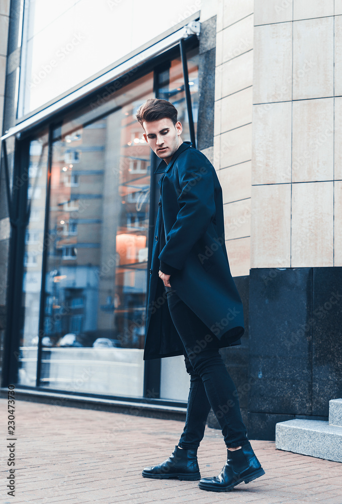 Portrait of young handsome stylish man in elegant coat. Outdoor fashion portrait.