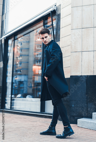 Portrait of young handsome stylish man in elegant coat. Outdoor fashion portrait.