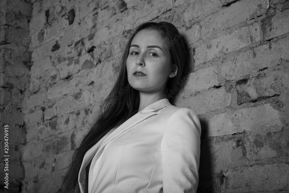 Black and white portrait of a young woman on a brick background. Black and white portrait of a young woman on a brick background.