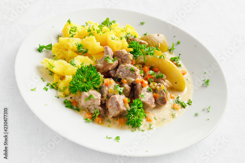 turkey stewed with apples, carrot, onion, and garlic garnished with potato and decorated with parsley