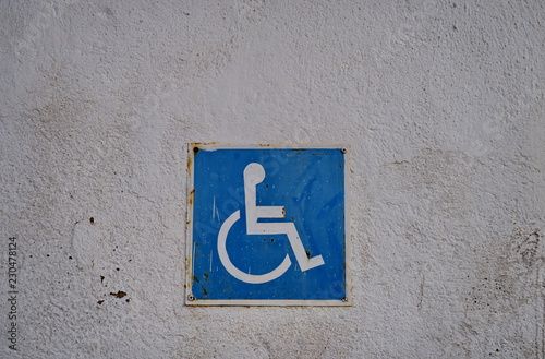 Panneau 'réservé aux handicapés' sur mur blanc