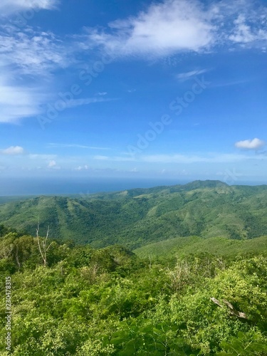 Mirador Lookout Point Panorama View close to Trinidad (Sancti Spiritus) in the Cuban Countryside (Caribbean island) with an untouched lush green vegetation and a blue summer sky with white clouds © ICW