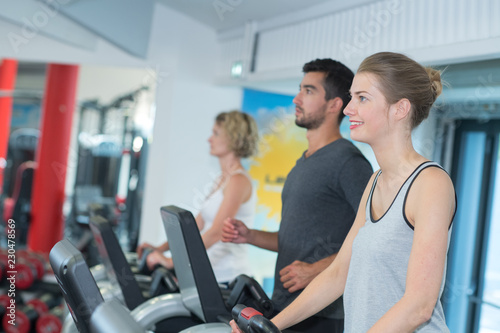 People using exercise machines in gym © auremar
