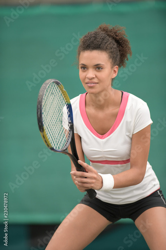 female tennis player in a receiving service stance