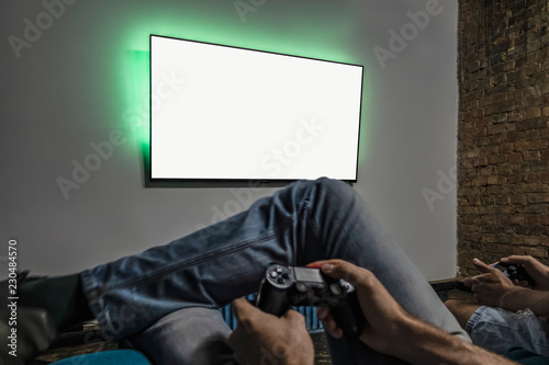 Two men playing video game. Clean monitor mockup. Hands holding console controller. Blank tv screen mock up. Widescreen tv hang on the wall.