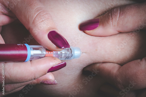 Young diabetic woman injecting herself with insulin
