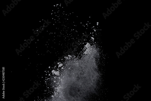 White powder explosion on black background. Dust splatted isolated. Paint Holi.