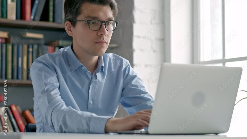 Male university student looking at laptop screen thoughtfully while doing homework. Closeup of concentrated boy trying to fulfill difficult task while studying Male university student looking at laptop screen thoughtfully while doing homework. Closeup of concentrated boy trying to fulfill difficult task while studying
