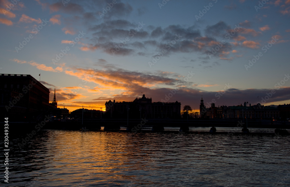 Evening view of Stockholm harbour with shilouettes of old town, parliament and famous landmarks