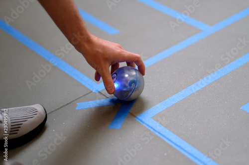 Man's hand with a luminous ball to play on the marked field