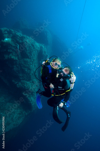 Happy couple scuba divers  hovering together on a safety stop
