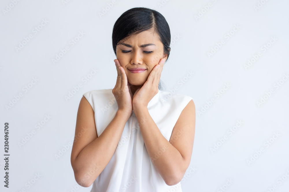 Smiling Asian girl enjoying face cream effect. Beautiful young woman closing eyes and touching cheeks. Beauty and skin care concept Smiling Asian girl enjoying face cream effect. Beautiful young woman closing eyes and touching cheeks. Beauty and skin care concept