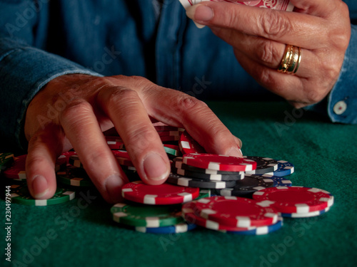 A person playing poker betting poker chips of various colors