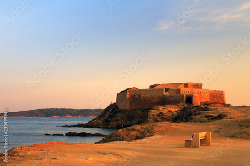 Amazing view of medieval fort fortress la tour fondue near Hyeres, southern France, in golden hours, the bench for contemplation in the foreground.   photo