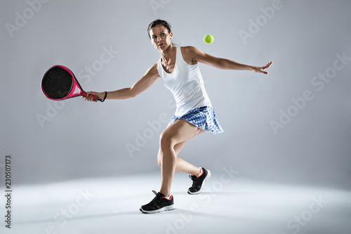 Adult fitness woman playing padel indoor. Isolated on white.