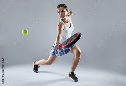 Adult fitness woman playing padel indoor. Isolated on white.