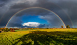 A stunning rainbow against dark clouds over rural fields in Suffolk, UK