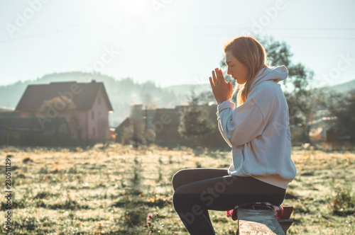Canvas-taulu In the morning Girl closed her eyes, praying outdoors, Hands folded in prayer concept for faith, spirituality, religion concept