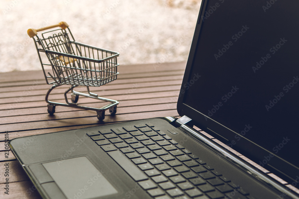Small trolley on a computer keyboard. Shopping sales concept. Small trolley on a computer keyboard. Shopping sales concept.
