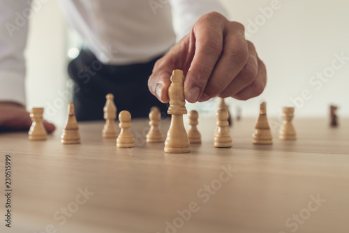 Businessman placing king chess figure forward
