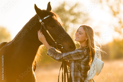 Girl equestrian rider stands near the horse. Horse farm © Rakursstudio