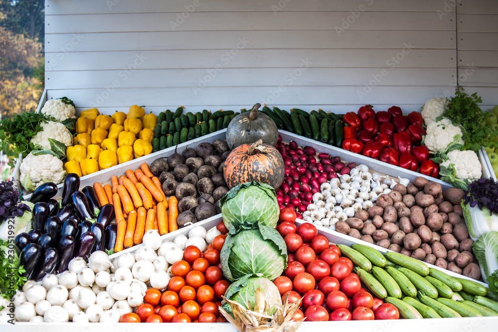 Assortment of fresh vegetables at market counter, vegetable shop, farmer marketplace. Organic, healthy, vegetarian diet food concept.