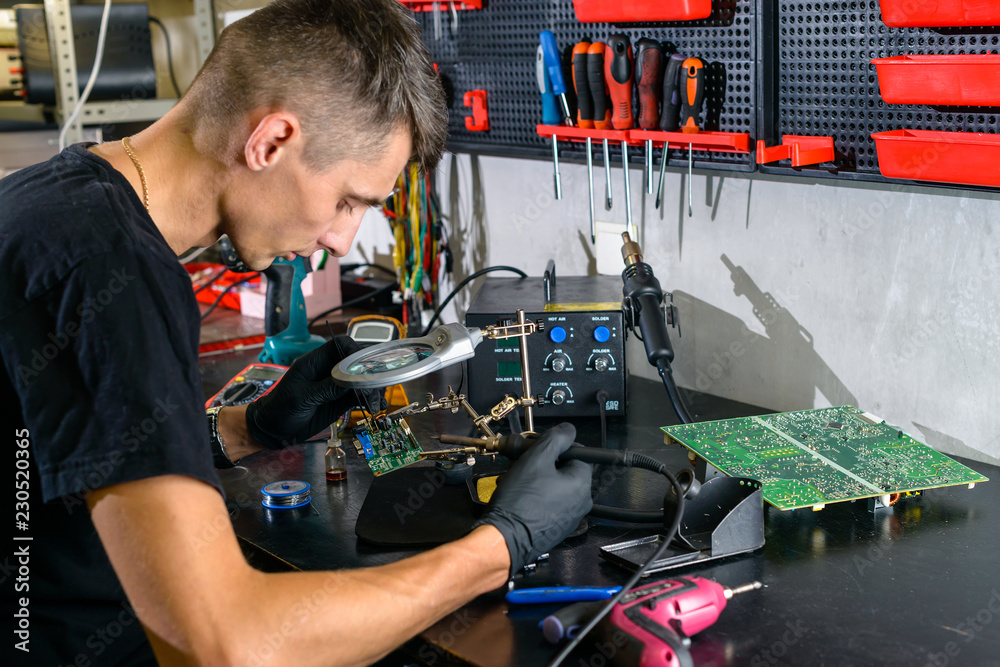 Professional repairman repairing computer in workshop close up