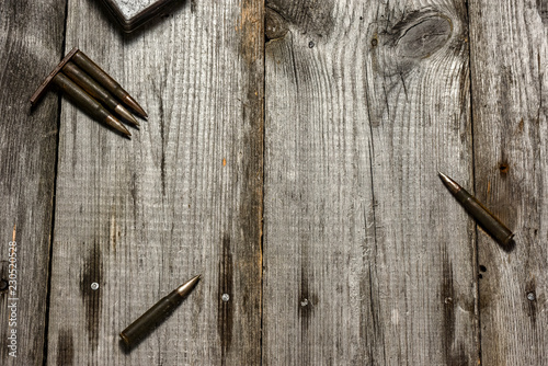 Disassembled clip with cartridges 7,92 x 57 - rustic ammos lies on the wooden background