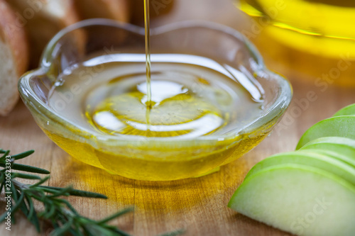 Olive oil being poured into bowl with Italian ingredients