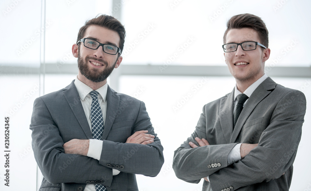 two confident businessman standing near the office window