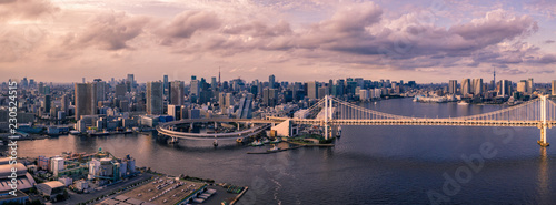 Aerial drone photo - Rainbow Bridge and the skyline of Tokyo at sunset. Capital city of Japan. 