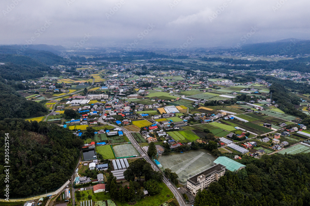 Aerial drone photo - The beautiful mountainous countryside of Japan.  The many rice fields, mountains, and villages of Gunma Prefecture.