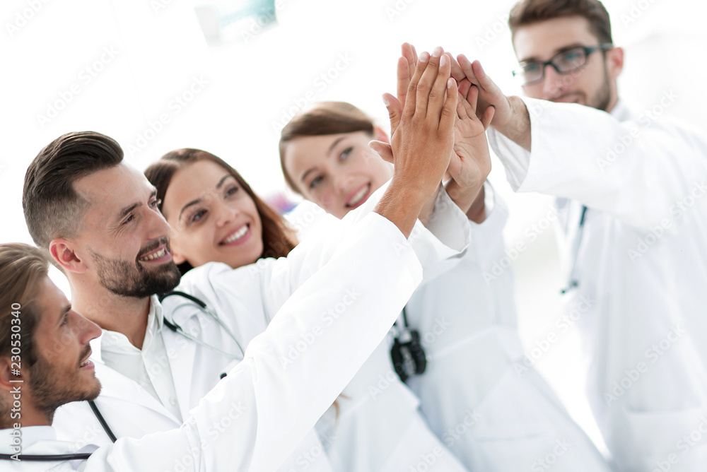 group of doctors giving each other a high five. group of doctors giving each other a high five.