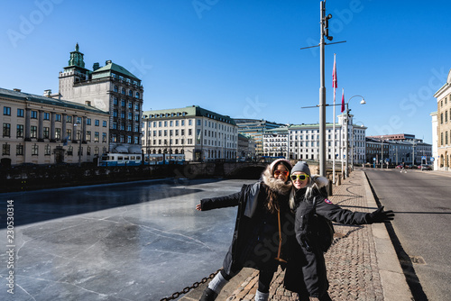 Two women posing in front of the canals of Gothenburg