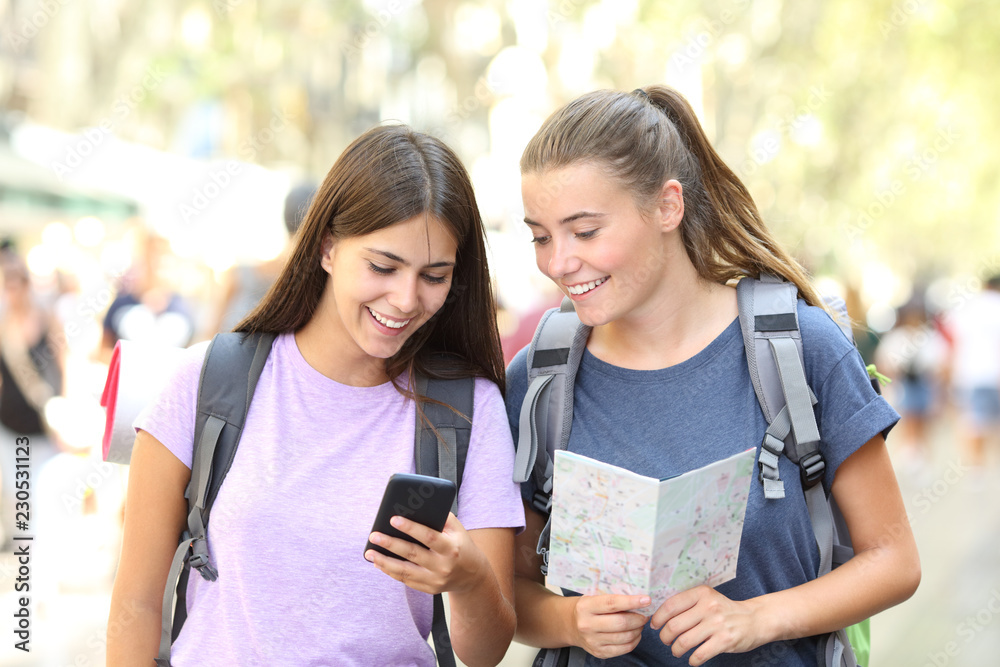 Happy backpackers consulting a guide outdoor Happy backpackers consulting a guide outdoor