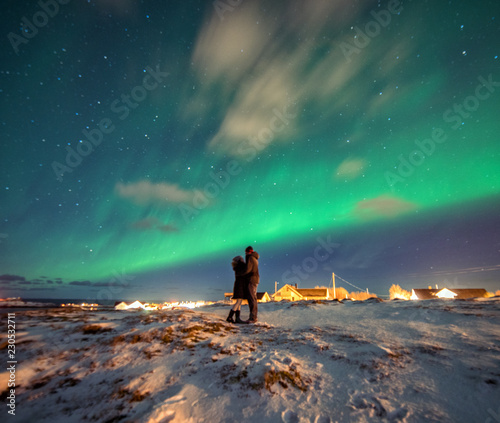 Obraz na płótnie A couple admires the Northern Lights in the mountains of Reine, Norway. Lofoten Islands w salonie