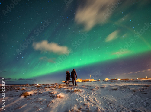 Obraz na płótnie A couple admires the Northern Lights in the mountains of Reine, Norway. Lofoten Islands w salonie