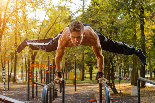 Athletic guy doing gymnastics outdoor photo