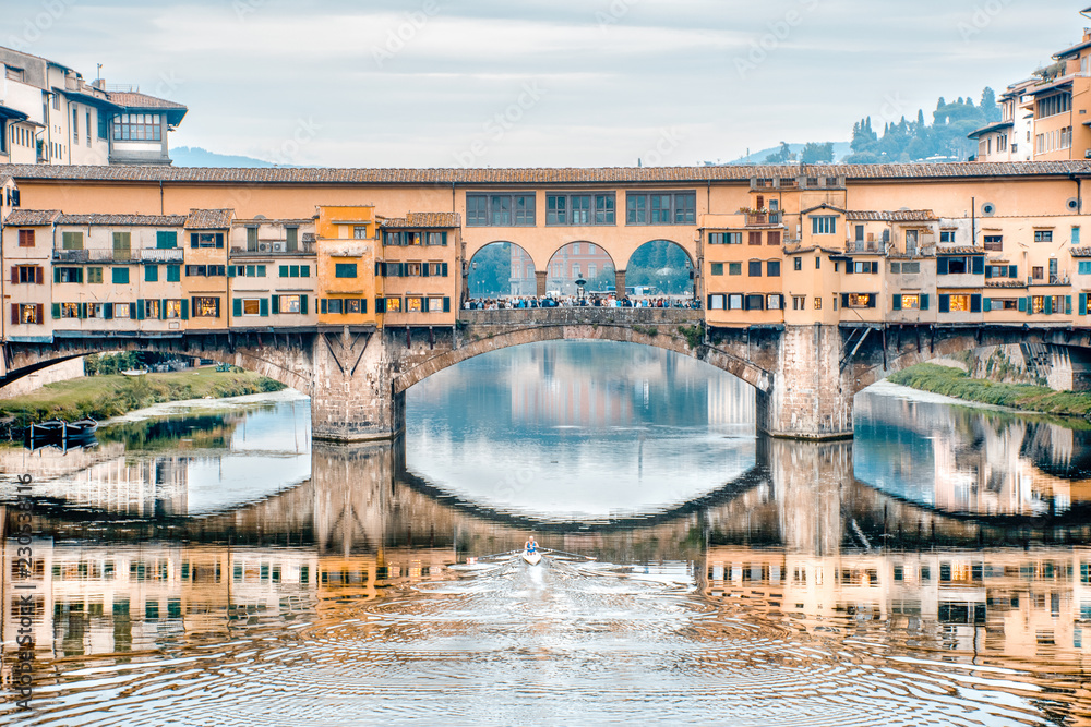 Obraz premium Remando no rio Arno. Vista da ponte vecchio em Florença e um atleta remando no rio. Obras de arte., arte para quadros fineart, impressão de quadros em alta qualidade. 