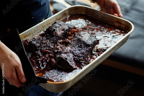Woman holding tray with baked meat