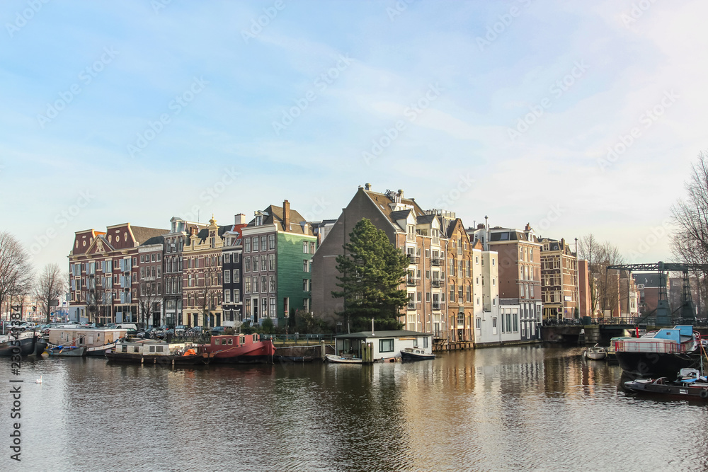 houses standing on the banks of the canals in Amsterdam