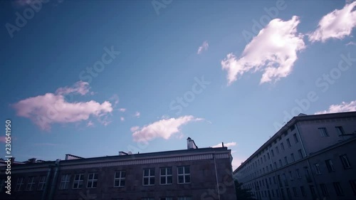 Motion timelapse of rolling clouds in the sky over an apartment complex in Warsaw, Poland photo
