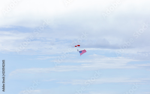 man parachuting high in the sky carrying american flag