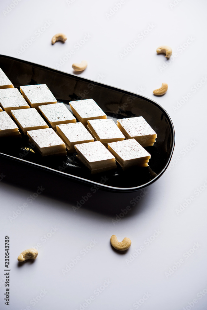 Kaju Katli is a Diamond shape Indian sweet made using cashew sugar and mava, served in a plate or bowl over moody background. selective focus Kaju Katli is a Diamond shape Indian sweet made using cashew sugar and mava, served in a plate or bowl over moody background. selective focus