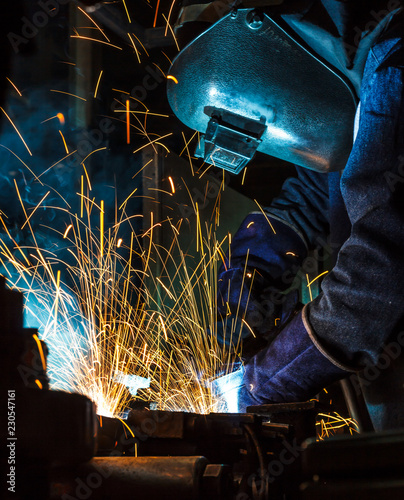 Worker welding the steel part by manua