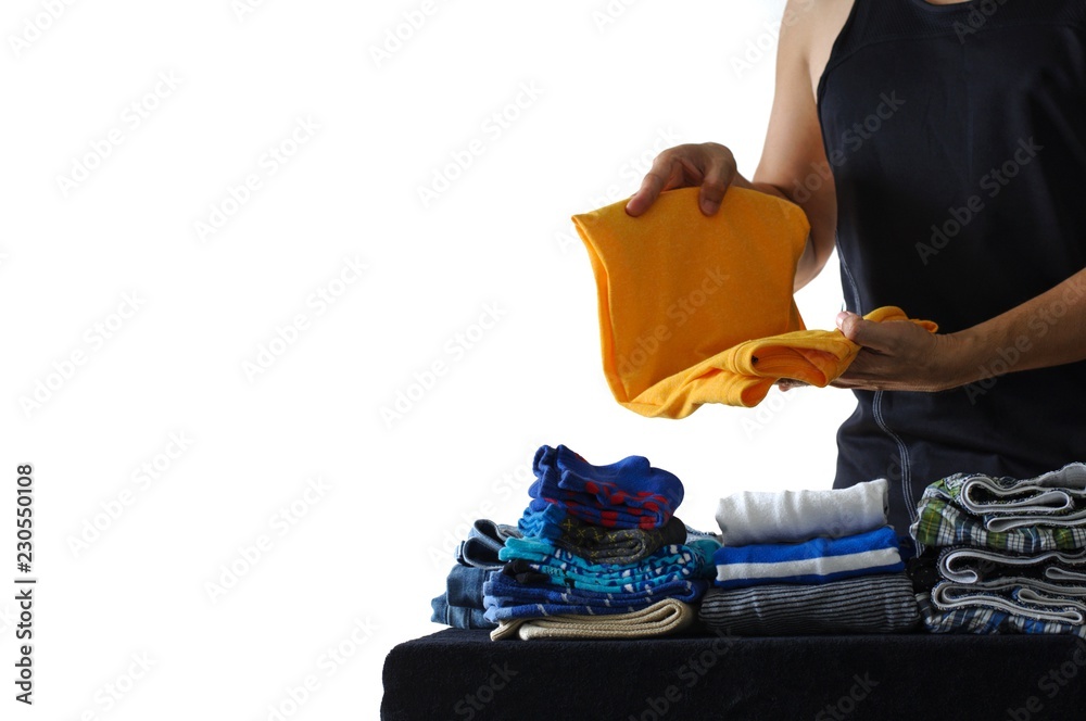 Obraz premium The man in non-stereotypical role doing housework folding his clothes. Photo isolated on white background with space for text.