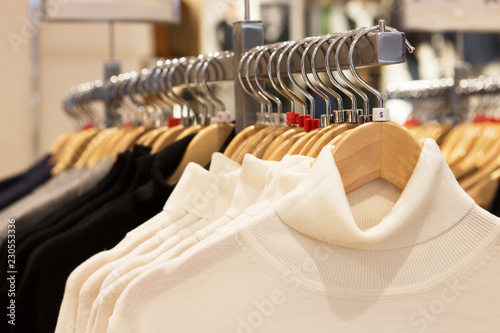 Clothes hanging on hangers in the store, choice of clothing concept