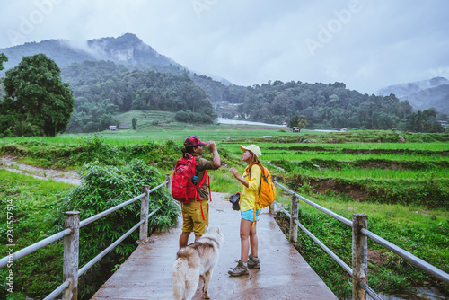 Lover asian man asian women travel nature. Walking a photo the rice field and stop take a break relax on the bridge at ban mae klang luang in rainy season.
