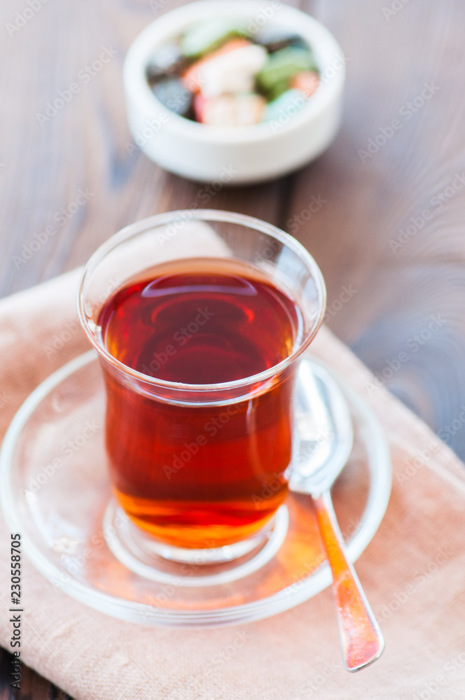 Turkish tea in authentic glass cup with delights. Closu up.